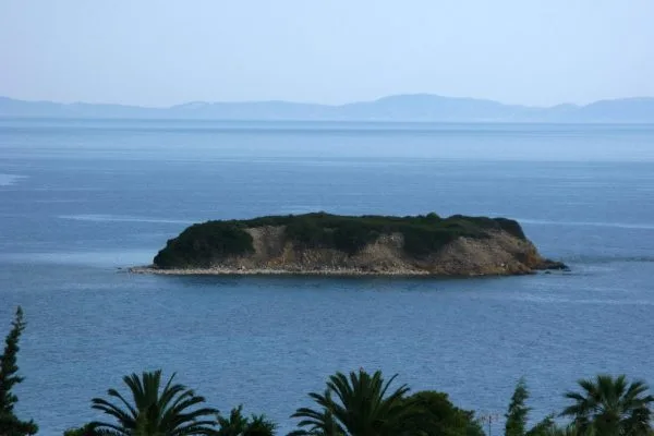 Малко обрасло островче в спокойното синьо море край Никити в Халкидики