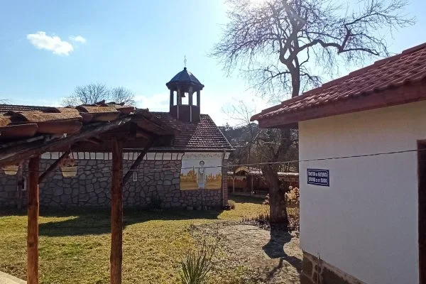 Дворът на храма с дървената камбанария