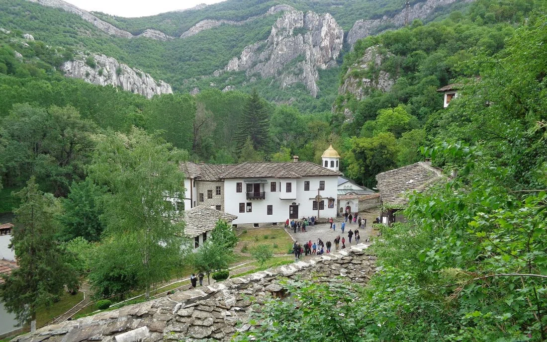 Белите сгради на Черепишкия манастир сред скалите край реката