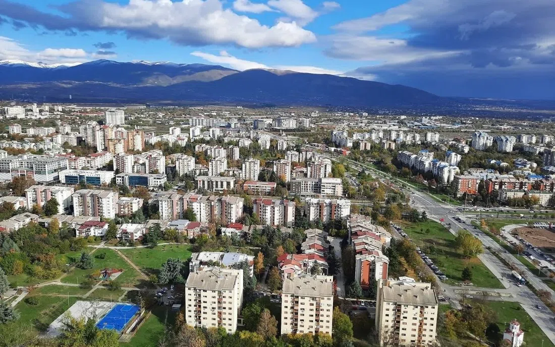 Панорама към Скопие с жилищните квартали и заснежените върхове зад тях