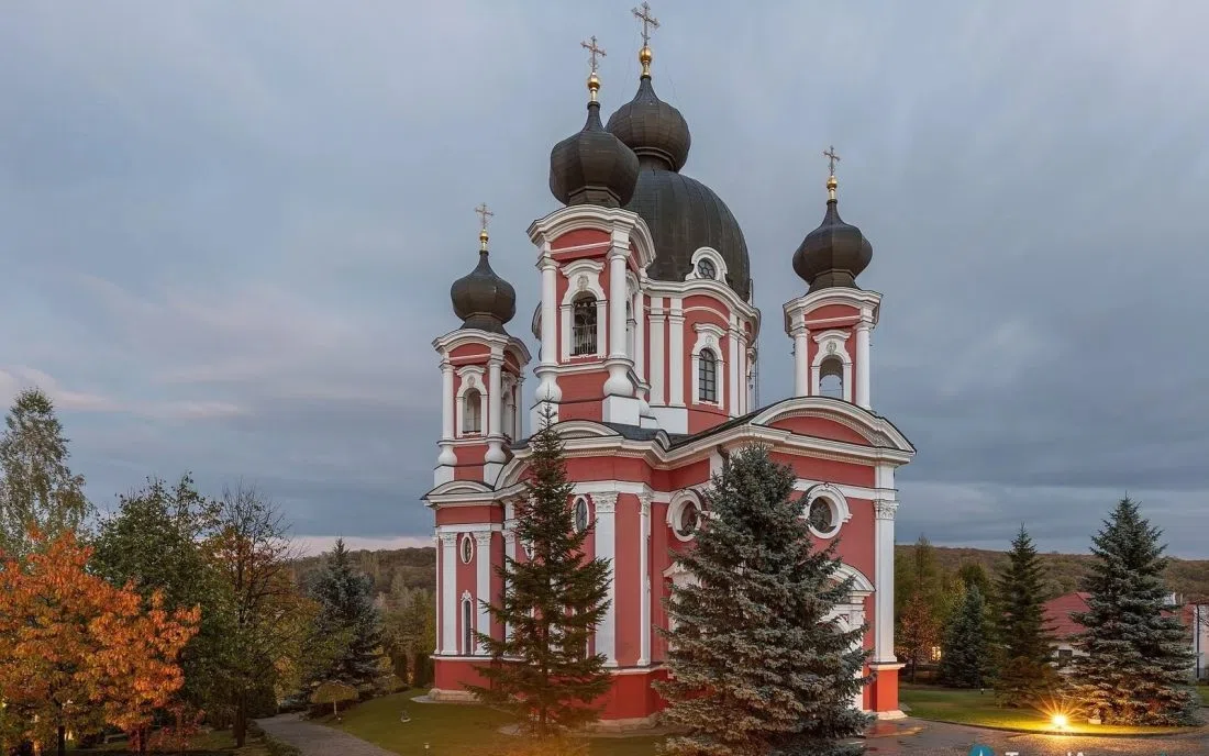 Православният манастир Курки в Молдова с червено бяла фасада и куполи