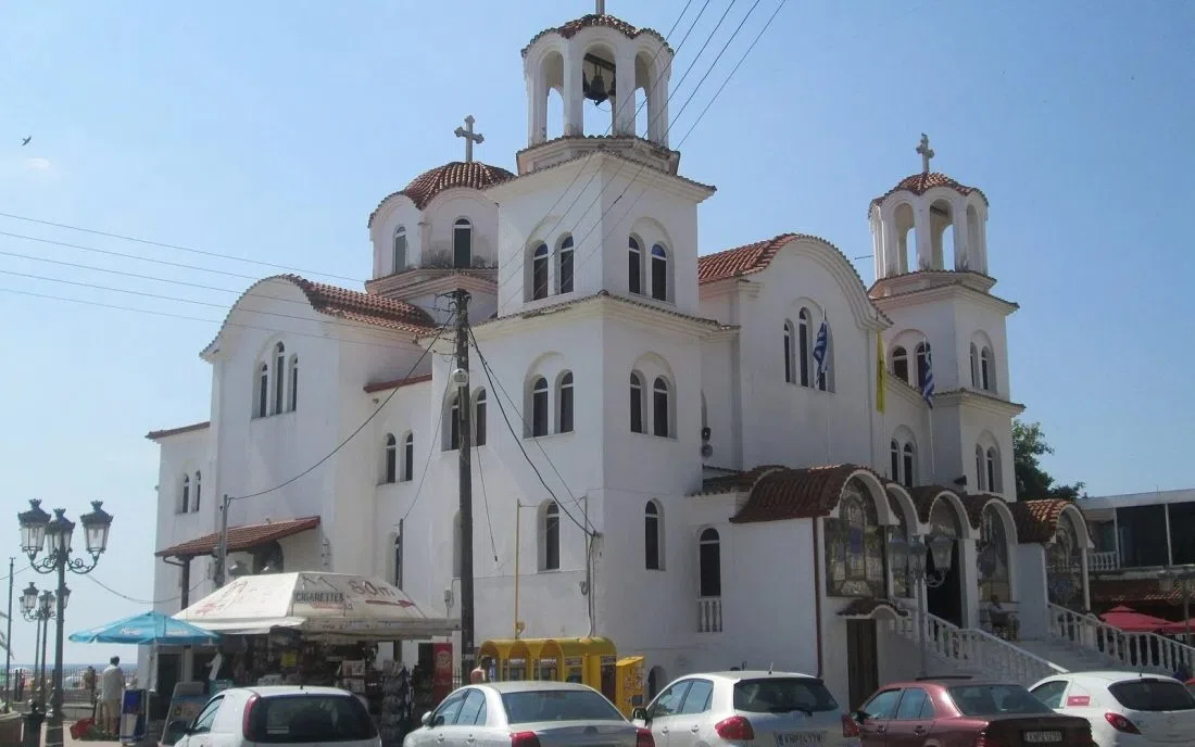 Православен храм с бели куполи и камбанария в Паралия Катерини