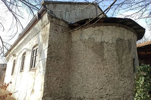 Старата каменна църква в близкото Сопово зад белосания зид