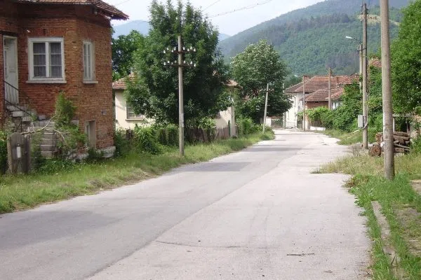 Тухлена къща с червен покрив на ъгъла край улицата в Стакевци
