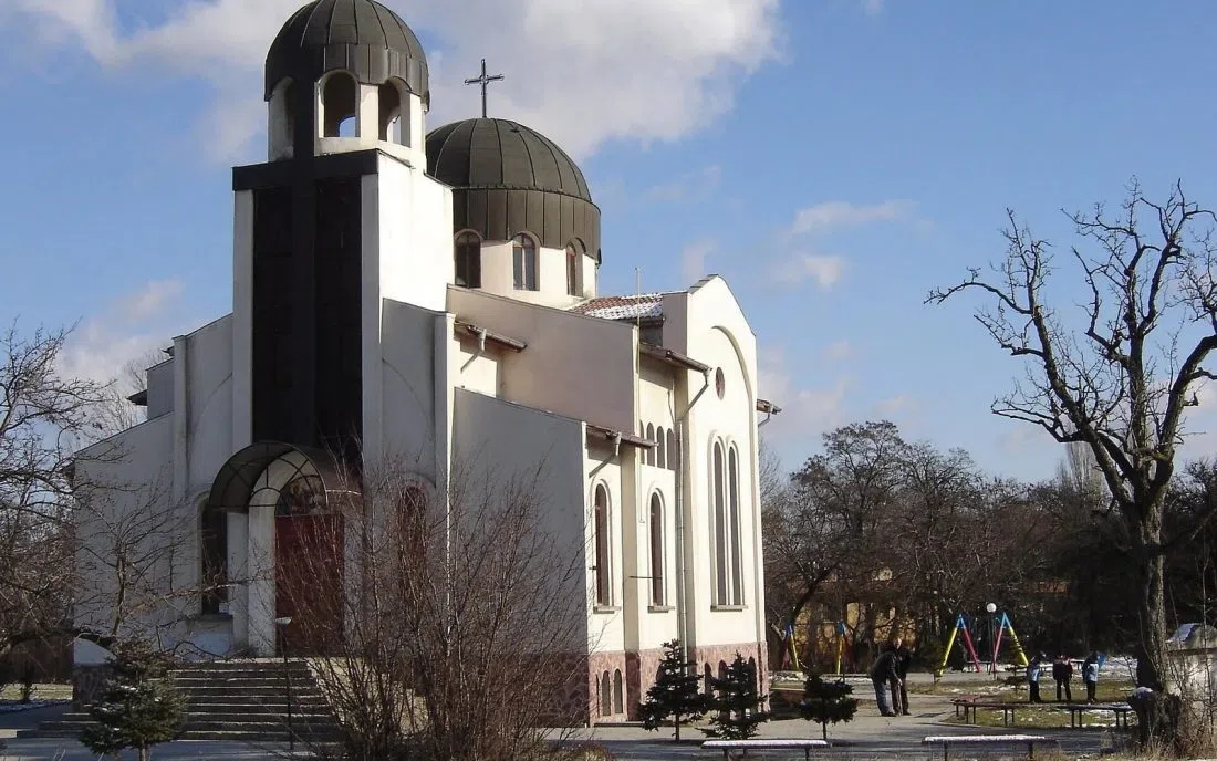 Бяла православна църква с две тъмни кубета и кръстове в Божурище