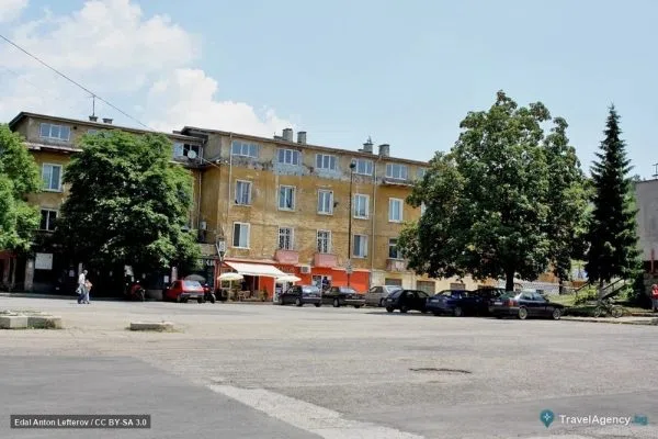 Централен площад в Бухово със стар жилищен блок и паркирани коли