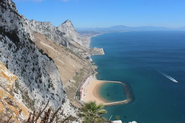 Гибралтарската скала се извисява над плажа и Средиземно море
