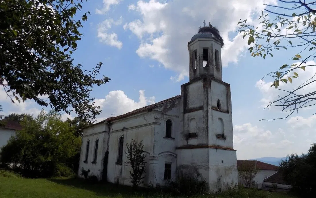 Бяла православна църква с камбанария и щъркелово гнездо в Гурково