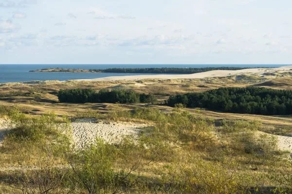 Тухленият островен замък Тракай, огрян в топла светлина под пълна луна над замръзналото езеро през зимата